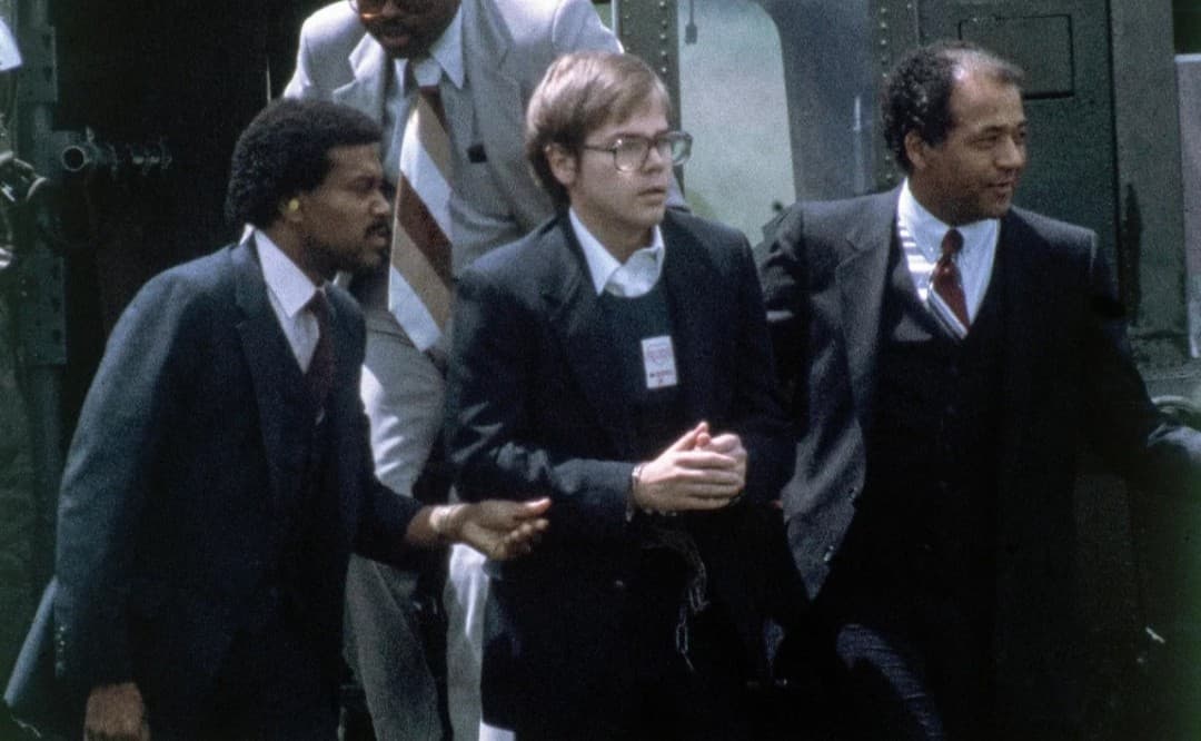 John Hinckley (tengah) dikawal aparat keamanan setelah menghadiri sidang percobaan pembunuhan Presiden Ronald Reagan, 8 Agustus 1981. Foto: SputnikNews