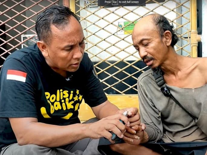 Aipda Purnomo merawat ODGJ. (Foto: Youtube/Purnomo Belajar Baik)
