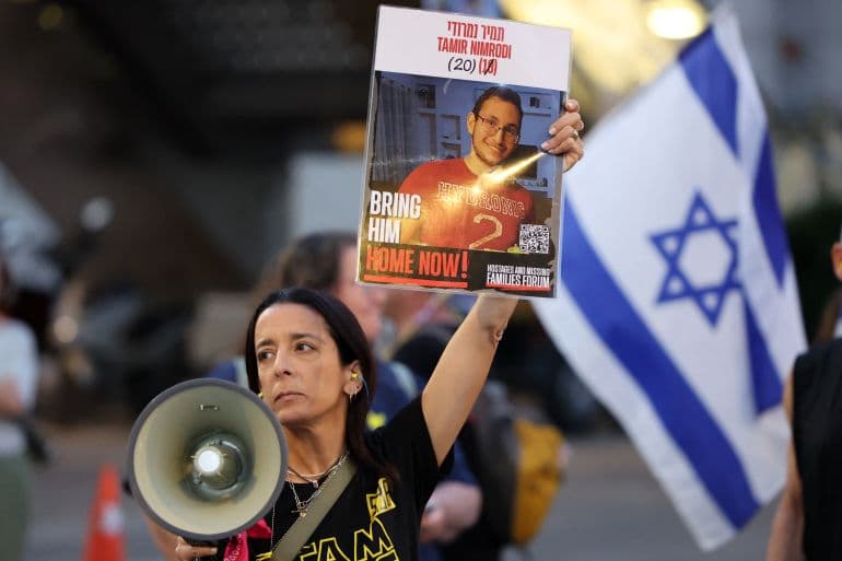 Seorang Warga Israel Mengangkat Poster Seorang Tawanan saat Demonstrasi Meminta Hentikan Perang di Gaza (Foto: AFP/Jack Guez)