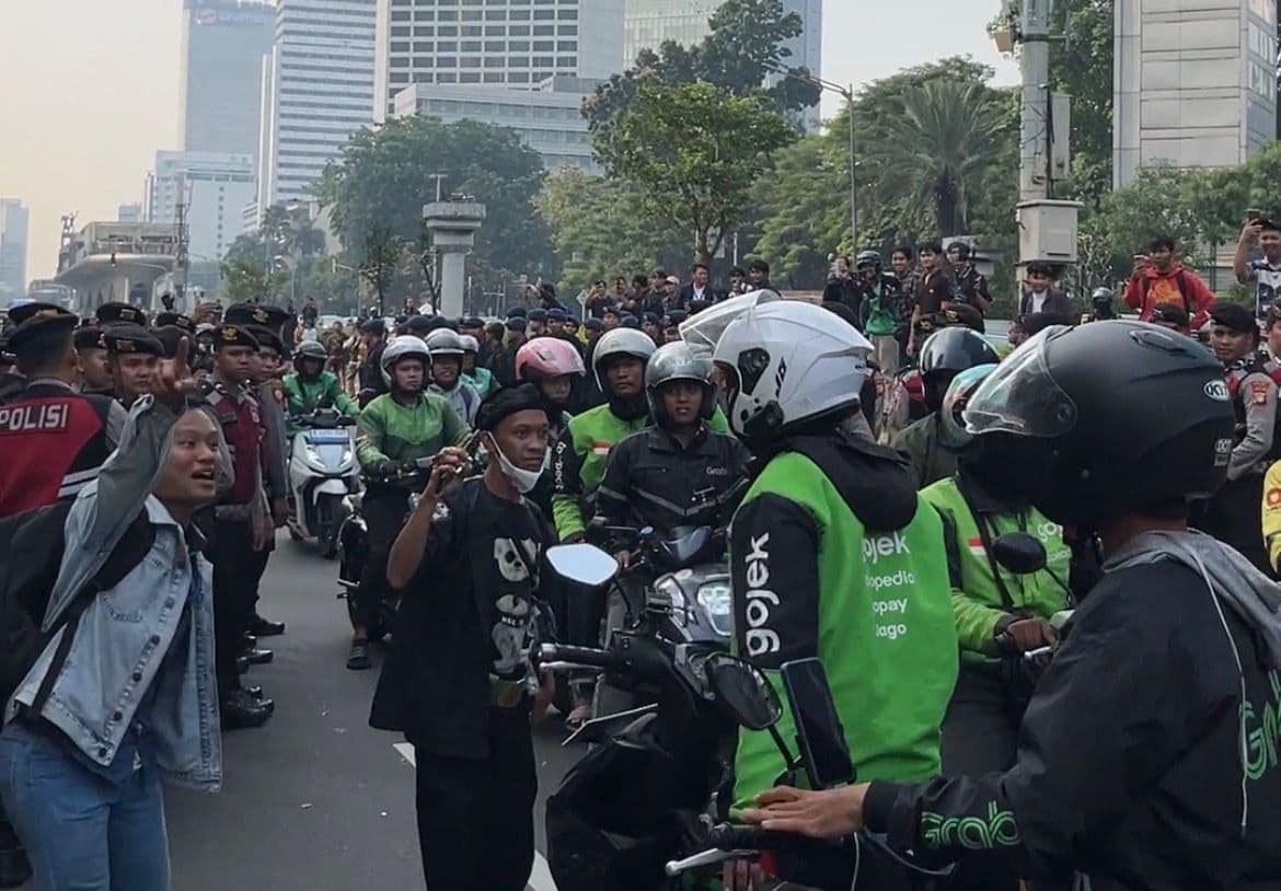 Puluhan driver ojek online menerobos blokade aparat di Jalan M.H Thamrin, Jakarta Pusat. (Foto: Hastina/REQnews)